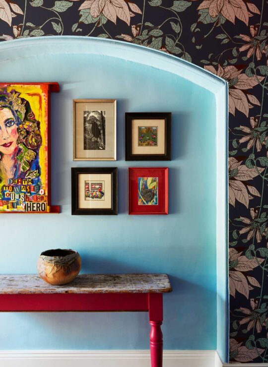 Bespoke painting of owner Laura with other curated paintings on wall in ImPossible House by Denby Dowling Interior Design