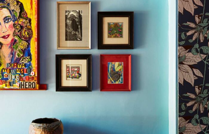 Bespoke painting of owner Laura with other curated paintings on wall in ImPossible House by Denby Dowling Interior Design